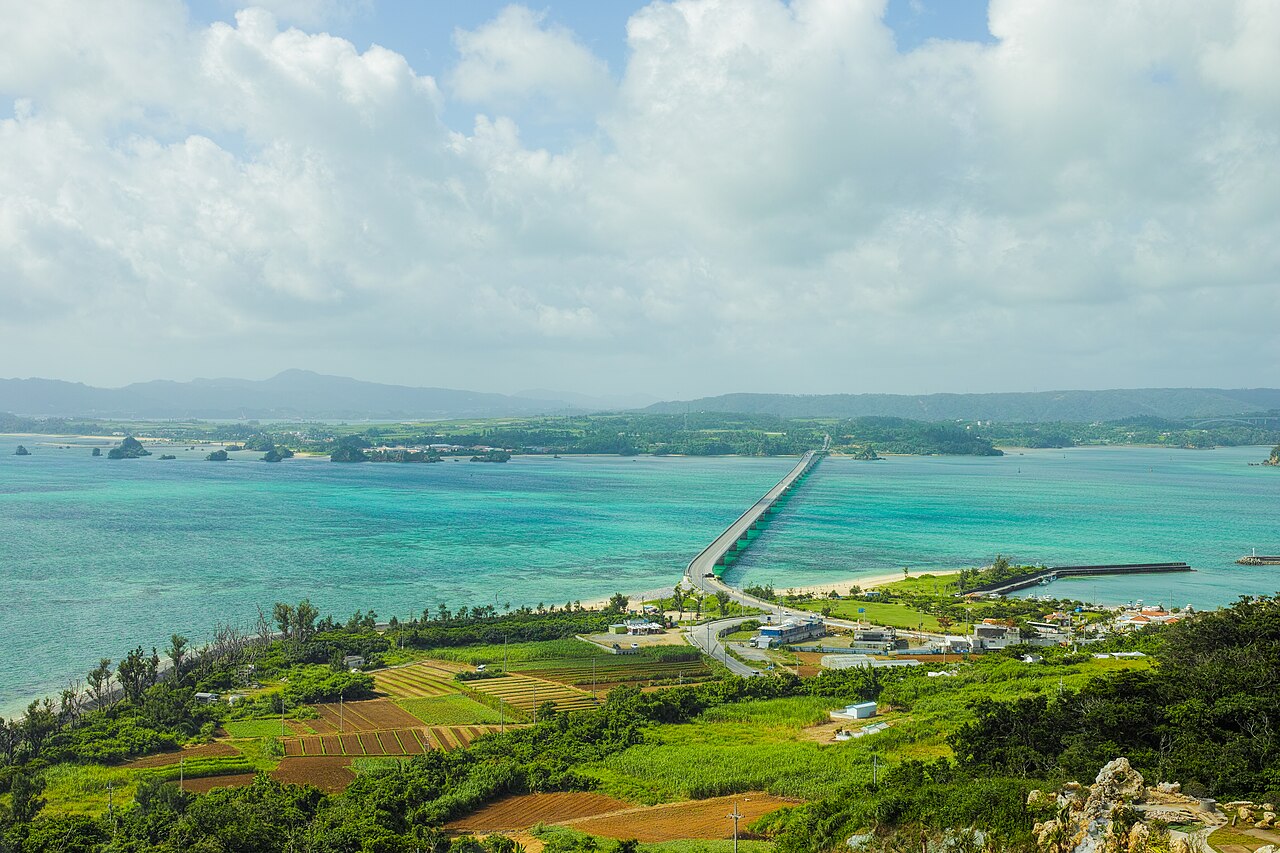 Kouri Bridge crossing turquoise shallows to Okinawa’s main island, seen from above Kouri Island’s farmland