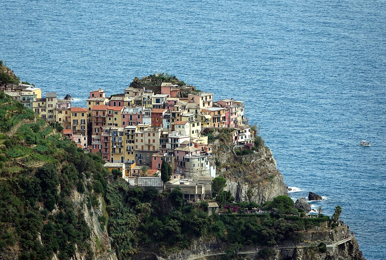 Colourful houses of Manarola stacked on a rocky cliff above the sea in the Cinque Terre, Italy
